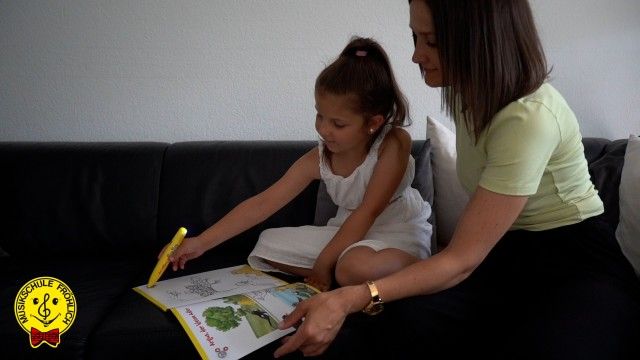 Mutter und Kind mit BOOKii-Trainings-Stift bei der musikalischen Früherziehung