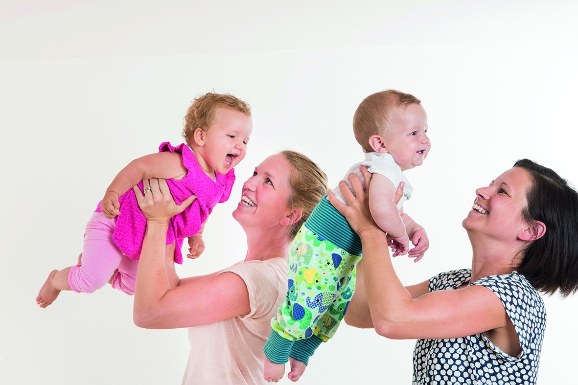 Mütter halten ihre Babys hoch